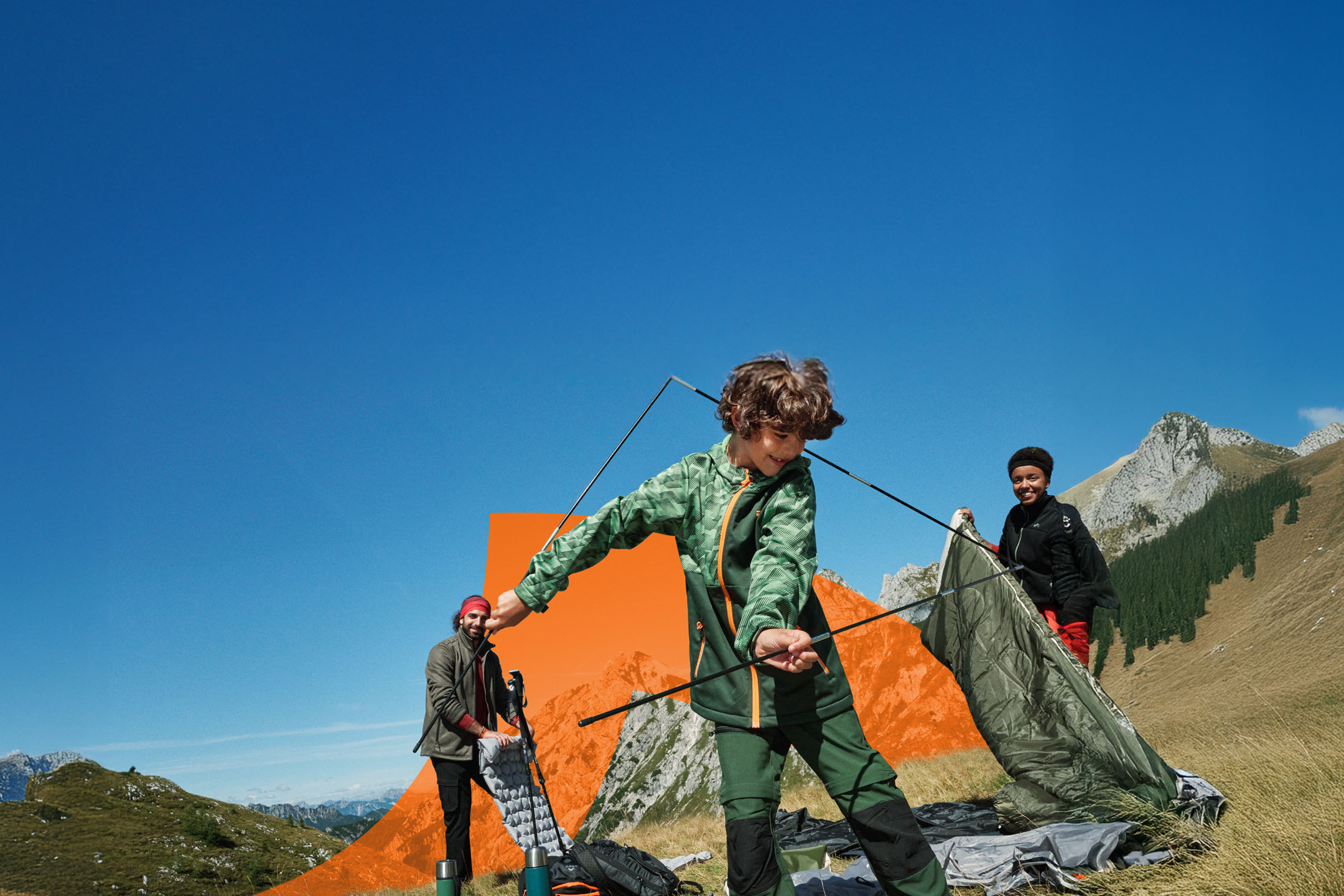 Familie montând un cort la munte, cu echipament de camping și îmbrăcăminte de exterior.