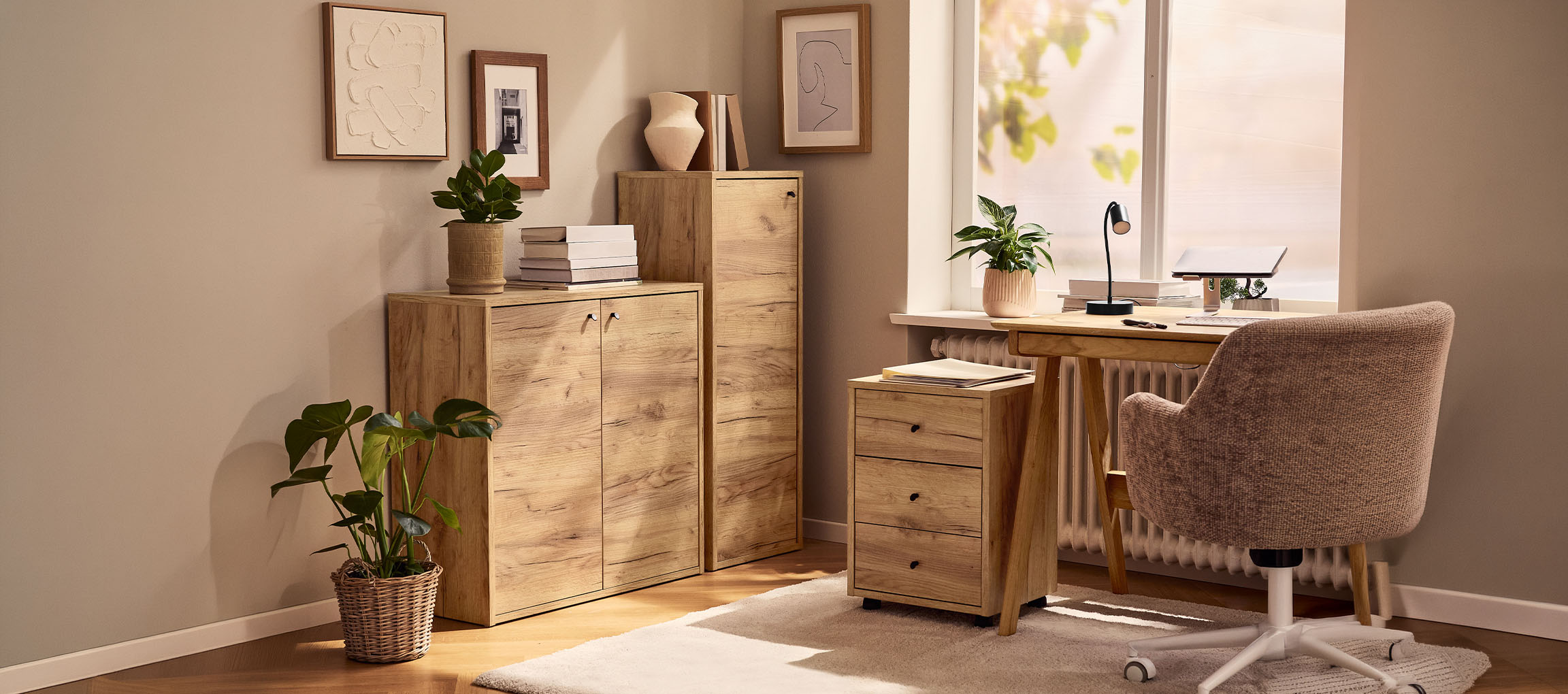 Birou de acasă cu dulapuri din lemn, birou și scaun, decorat cu plante și tablouri.