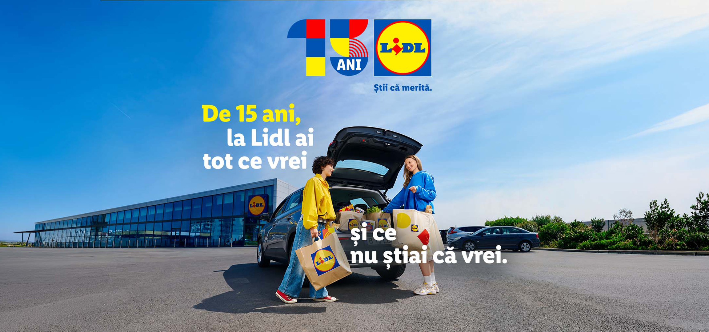 Două femei încarcă cumpărături în portbagajul unei mașini, cu textul 'De 15 ani, la Lidl ai tot ce vrei și ce nu știai că vrei'.