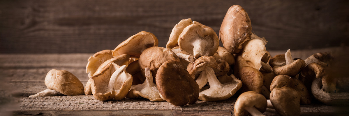 Ciuperci shiitake și alte ciuperci pe masă din lemn.