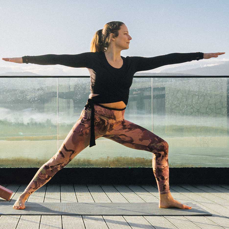 Femeie în colanți și top de yoga pe o terasă