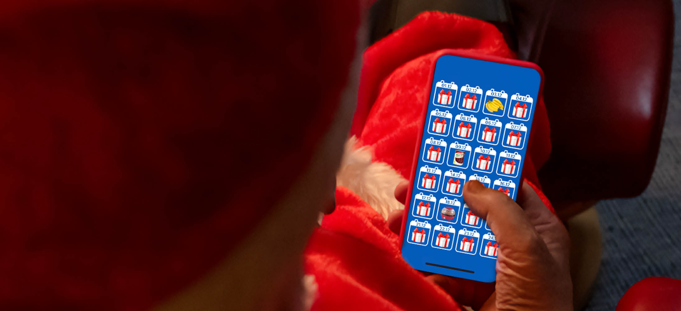 O persoană în costum de Moș Crăciun ține un telefon cu un calendar de Advent digital.