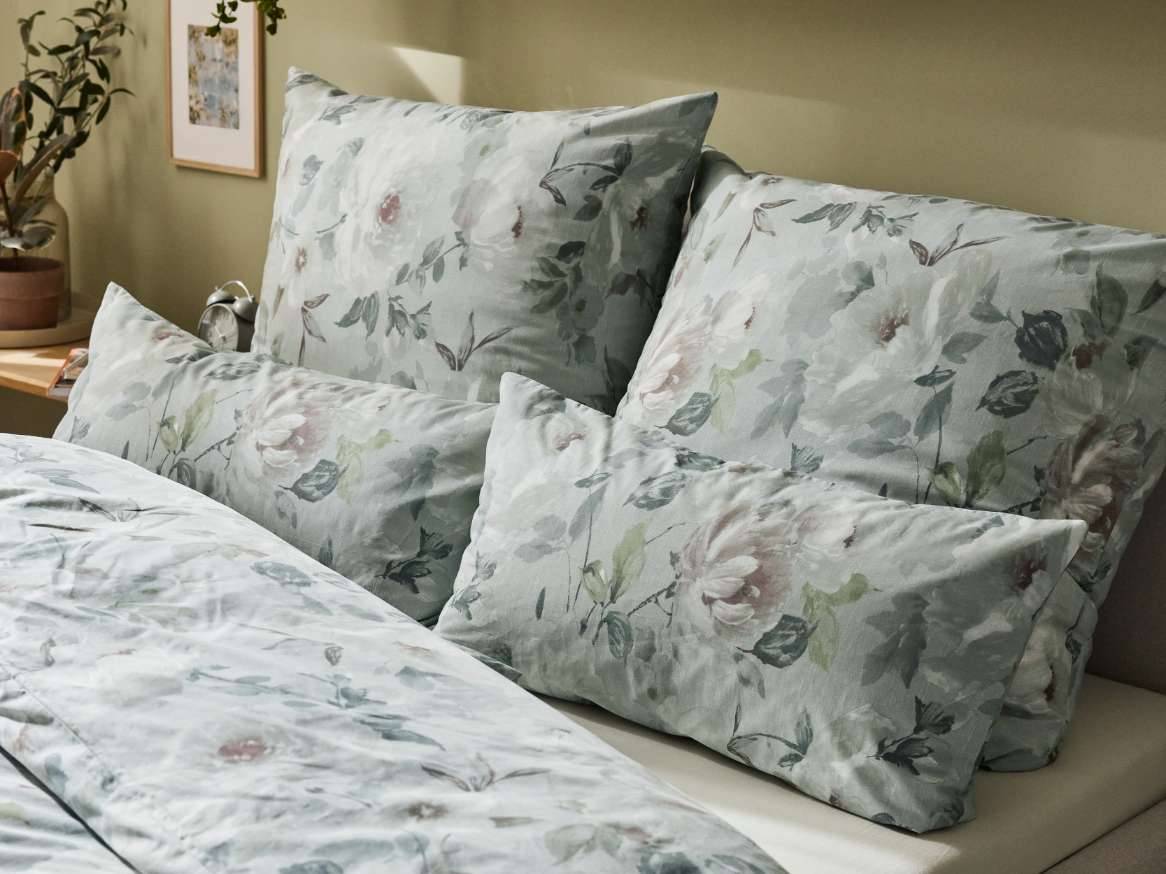 Set de lenjerie de pat cu imprimeu floral, în nuanțe de verde-albăstrui.
