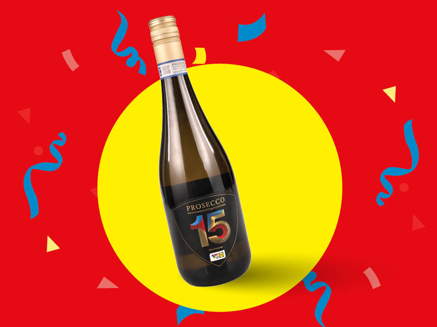 O sticlă de Prosecco aniversară cu numărul 15, pe un fundal festiv roșu și galben.