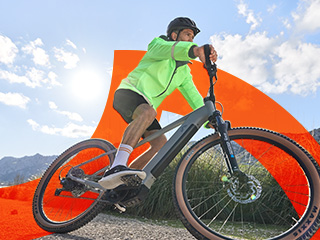 Un bărbat merge cu bicicleta electrică pe un drum.