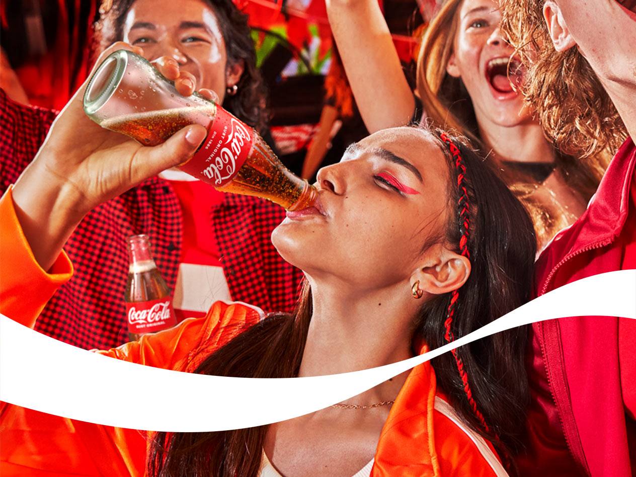 Tineri entuziaști beau băuturi răcoritoare din sticle de sticlă la un eveniment.